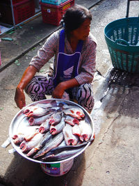 High angle view of woman selling fish in market