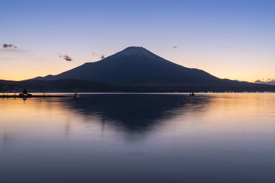 Scenic view of lake and mountain against sky during sunset