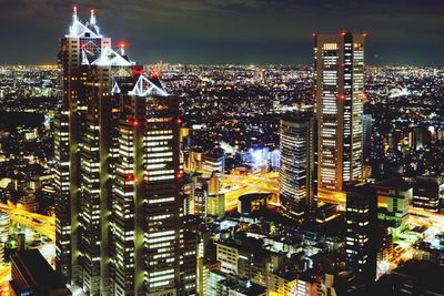 Illuminated cityscape against sky at night