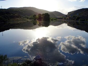 Scenic view of calm and mountains against sky