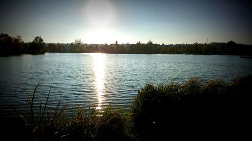 Scenic view of lake against clear sky during sunset
