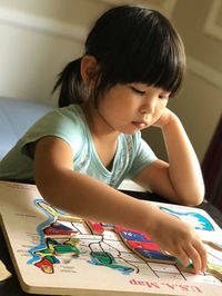 Girl playing puzzles at home