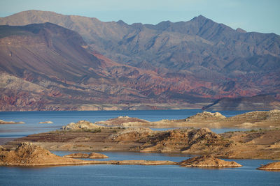 Scenic view of sea and mountains against sky