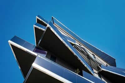 Low angle view of modern building against clear blue sky