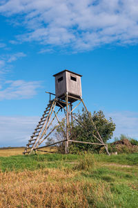 Low angle view of windmill on field against sky