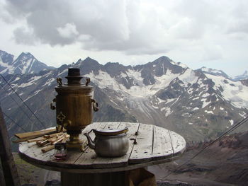 Table with samovar snd bread with mountains on background