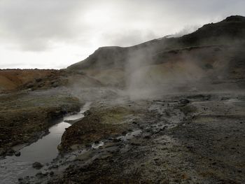 Hot spring on landscape against sky