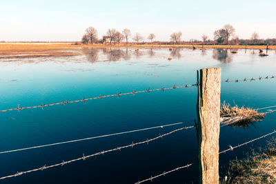 High angle view of wooden post in lake against sky