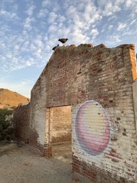 Low angle view of seagull on old building against sky