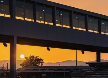 Low angle view of illuminated bridge against sky during sunset