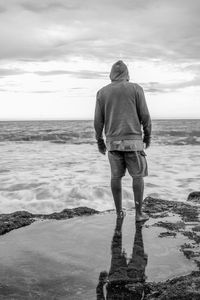 Rear view of man standing at beach