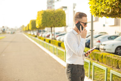 Young man using mobile phone on road