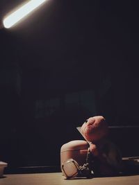 Close-up of man holding wineglass against table