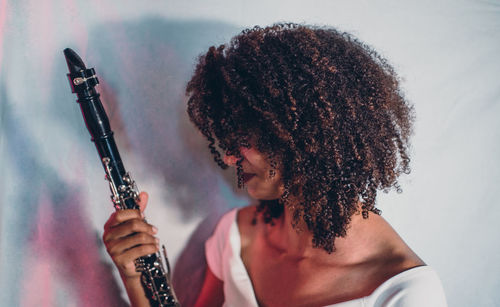 Side view of young woman holding guitar