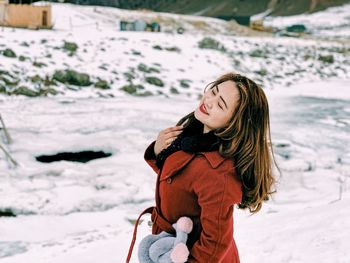 Beautiful woman standing on snow covered land