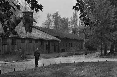 Rear view of man walking on street by building