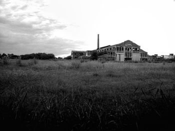 Abandoned house on field against sky