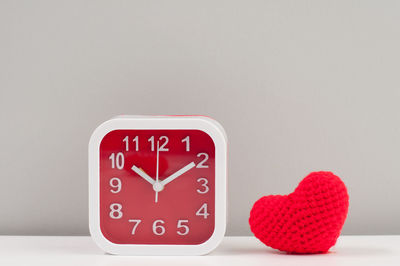 Close-up of heart shape on red table against white background