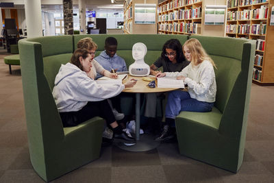 Friends sitting together in library