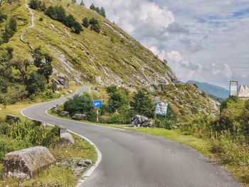 Road amidst green landscape against sky