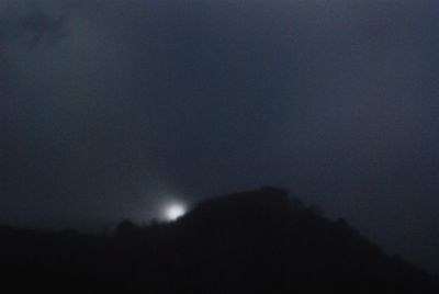 Low angle view of silhouette mountain against sky at night