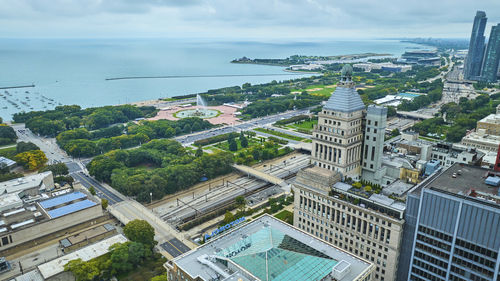 High angle view of cityscape by sea against sky