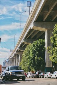 Cars on bridge in city against sky