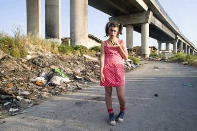 Full length of woman standing on road against sky