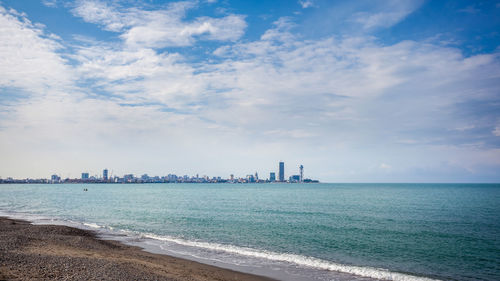 Panoramic view of sea and buildings against sky