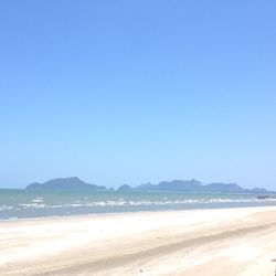 Scenic view of beach against clear blue sky