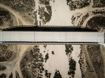 Reflection of bridge in puddle on road