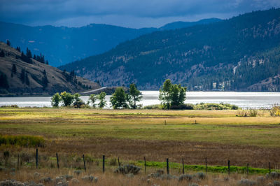 Scenic view of field and mountains against sky