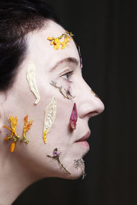 Close-up portrait of young woman against black background