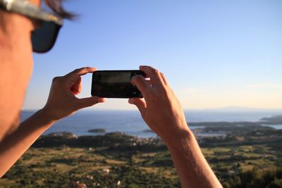 Cropped image of woman photographing through smart phone