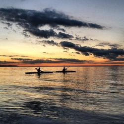 Side view of silhouette boating in calm sea