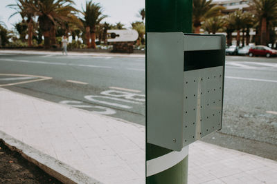 Close-up of mailbox on pole against road
