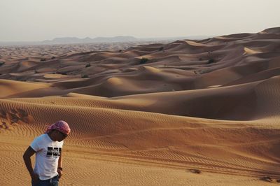Man standing on sand dune in desert