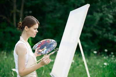 Side view of young woman using mobile phone