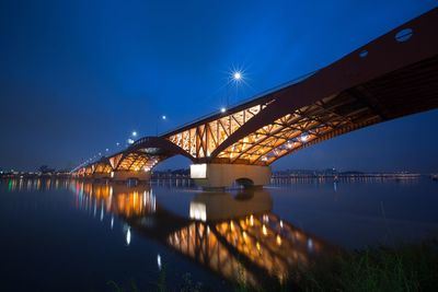 Low angle view of bridge over river at night