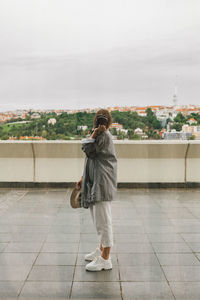 Rear view of woman photographing against sky