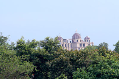 View of trees and building against sky