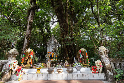 Statue by trees against temple