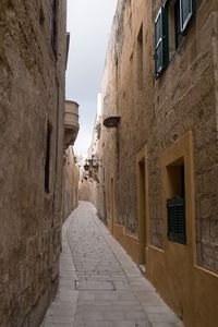 Narrow alley amidst buildings against sky