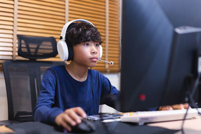 Teenage boy doing homework on computer at home.