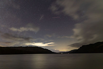 A view of the night sky over ullswater in the english lake district on a cloudy winters night