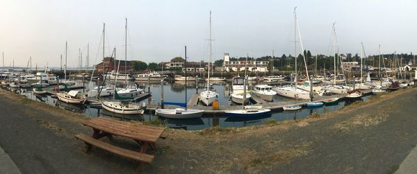 Sailboats moored at harbor