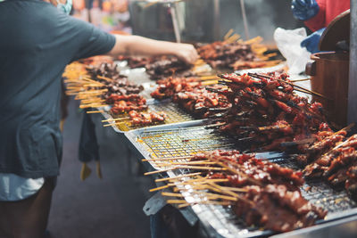 Midsection of man preparing food at market