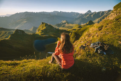 Rear view of woman walking on mountain against sky