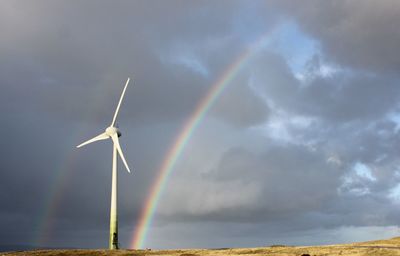 Low angle view of wind turbines on rainbow