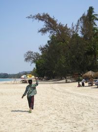 Rear view of woman on beach against sky